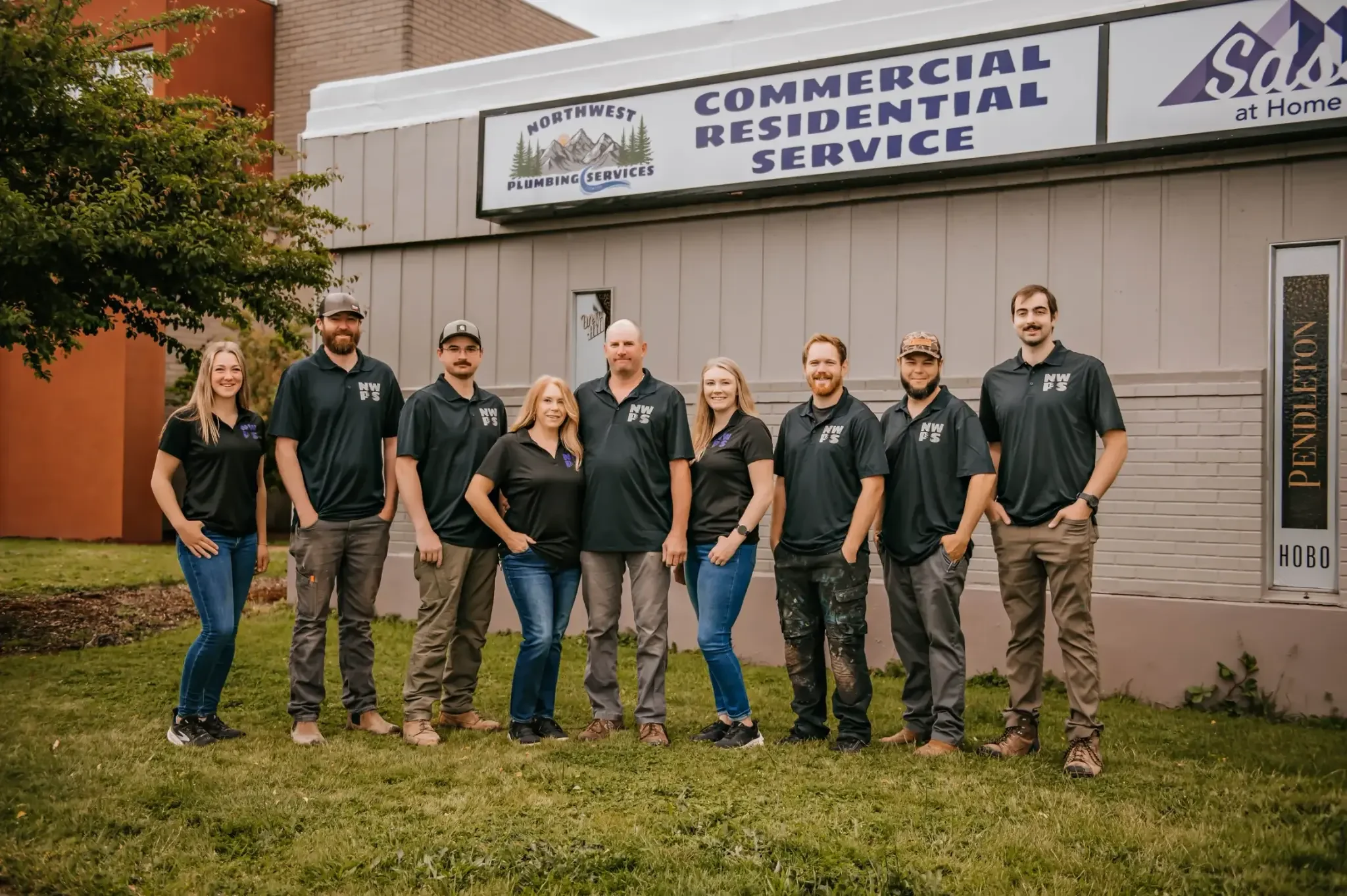 The complete Northwest Plumbing Services team standing outside the St. Helens storefront